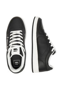 Mustad mustad sneakers valgeteltidega ja nööridega, diagonaalne külgmine logo, esitletud ülal- ja külgvaates valgel taustal.