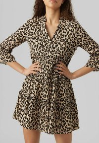 Robe imprimée léopard avec un col, des manches trois-quarts, des volants à étages et une taille cintrée dans des tons beige et noir.