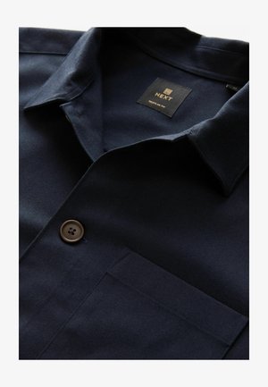 Marineblaues kurzärmliges Hemd aus glattem Stoff, mit Knopfverschluss, Brusttasche und einem Kragen mit Steppdetails.