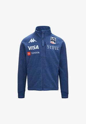 Giacca sportiva blu con zip, con il logo del Team Sci USA e i loghi degli sponsor Kappa, Visa, Toyota e Stifel sul davanti.