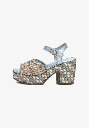 Sandalias de plataforma trenzadas con una correa metálica azul, detalles trenzados en beige y azul, puntera redonda, tacón grueso y hebilla en el tobillo ajustable.