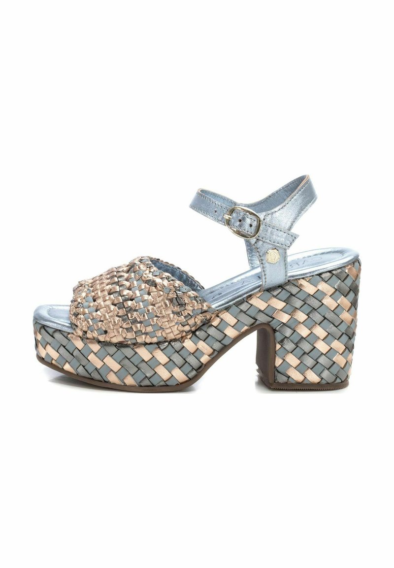 Sandalias de plataforma trenzadas con una correa metálica azul, detalles trenzados en beige y azul, puntera redonda, tacón grueso y hebilla en el tobillo ajustable.