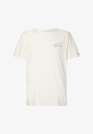 T-shirt blanc à manches courtes et col rond avec un petit logo vert "Tommy" sur la poitrine gauche et un petit emblème de drapeau sur la manche gauche.