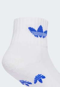 Calzino bianco alla caviglia con logo ricamato a tre foglie blu e accenti rigati. Texture a costine sul polsino e materiale complessivamente liscio.