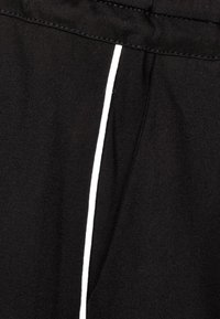 Czarne spodnie materiałowe z kontrastowym białym paskiem po bokach, gładką fakturą, elastycznym pasem i przeszyciami.