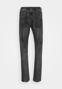 Černé džíny z denimu s úzkým střihem, které mají dvě zadní kapsy a jemné vyblednutí. Pás má kontrastní zelený akcent.