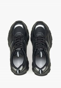 Černé sportovní tenisky s síťovanou svrchní částí, polstrovaným jazykem a texturovanou podrážkou. Reflexní akcenty a kontrastní šedé detaily.