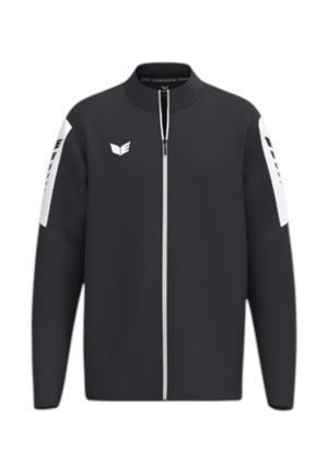 Schwarze Sportjacke mit Reißverschluss, weißen vertikalen Streifen an den Ärmeln und kleinem weißem Logo auf der linken Brustseite.