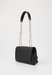 Black faux leather handbag with a structured shape, chain strap, and metallic accents; features a flat front pocket and textured surface.
