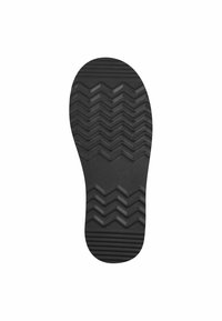 Semelle de chaussure en caoutchouc noir avec un motif de semelle en zigzag et des détails nervurés, dotée d'une surface lisse sur les bords.
