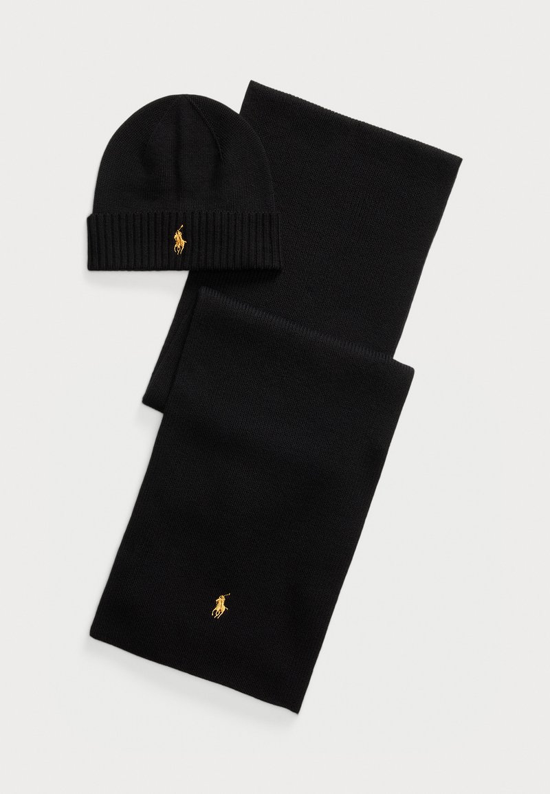 Conjunto de gorro de malha preta e lenço. Apresenta textura canelada e acentos em dourado. Tecido suave com um design elegante, adequado para o tempo frio.