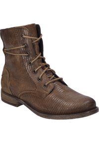 Botas marrones de cordones con un patrón texturizado y embosado. Hechas de cuero, cuentan con una punta redondeada y un tacón bajo apilado. Cuerdas neutras.