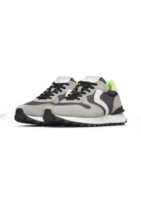 Le sneaker grigie e viola presentano una tomaia in suede e mesh, con lacci neri e un accento bianco. Una fodera interna verde aggiunge un contrasto.