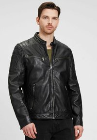 Zwarte leren jas met een staande kraag, ritssluiten op de zakken, gewatteerde schouderdetails en een gladde textuur. Klassiek, aansluitend ontwerp.