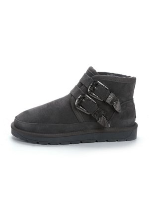 Botas de tobillo de ante gris con dos hebillas decorativas y detalles de costura. Suela de goma con un acabado texturizado. Diseño de punta redonda.