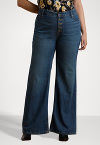 High-waisted wide-leg jeans in dark blue denim, featuring a button-up front, five pockets, and a classic straight silhouette.