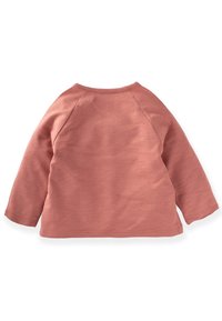 Dlhý rukáv top v jemnej ružovej farbe, vyrobený z mäkkého bavlneného materiálu, s okrúhlym výstrihom a raglánovými rukávmi s hladkou textúrou.