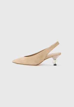 Chaussure slingback en suède beige avec un nez pointu et un talon transparent et arrondi. Texture lisse et design minimaliste.