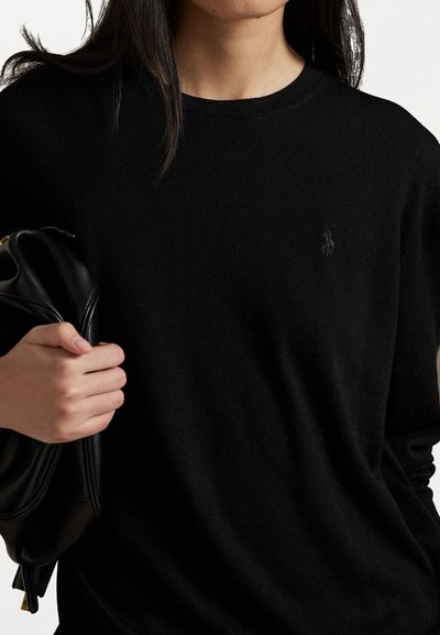 Black knitted sweater featuring a crew neck and a small embroidered logo on the chest. The fabric appears soft with a fine texture.