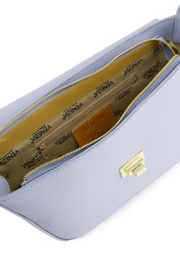 Lyseblå læderhåndtaske med en tekstureret overflade, guld hardware og lynlås lukning. Indvendigt har den en guld foring og flere lommer.