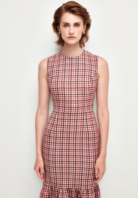 Ruokapuku ilman hihoja punaisena, valkoisena ja tummansinisenä. Tiukka vartalonmyötäinen yläosa ja levenevä helma, valmistettu kevyestä kankaasta.