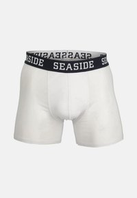 Hvide boxershorts til mænd med sort elastisk linning med ordet "SEASIDE" i hvide store bogstaver.
