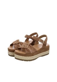 Brown suede platform sandals with a woven jute midsole, adjustable straps, and a knotted detail on the toe. Flat rubber outsole.