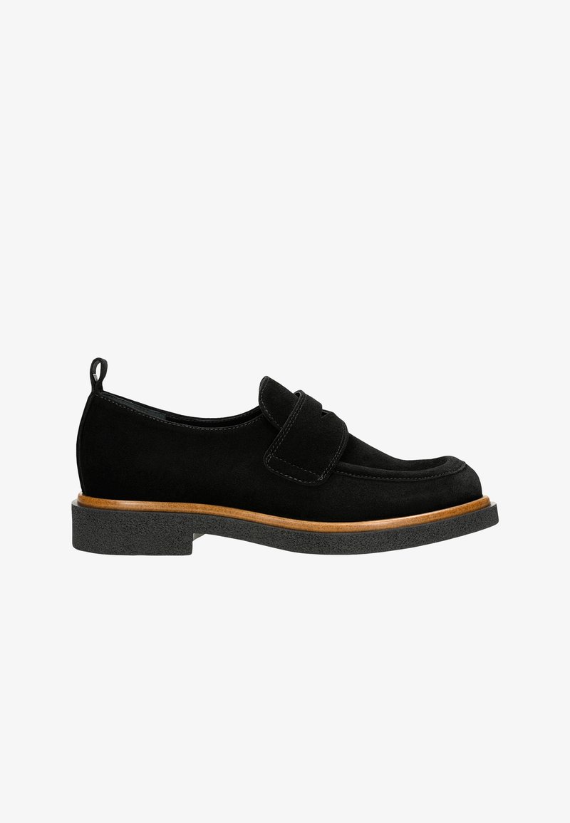 Mocassins en suède noir avec un bout arrondi, présentant une lanière sur le dessus, une semelle en caoutchouc noir texturé et une accent en bois au niveau de la semelle intermédiaire.