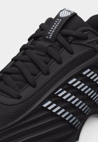 Μαύρο αθλητικό παπούτσι με υφασμάτινη υφή, ενισχυμένα κορδόνια και λεπτομέρεια λευκής ρίγας στη σόλα με την επιγραφή "Hypercourt Express 3".