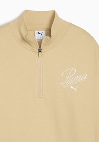 Beige zip-up sweatshirt med høj krave, lavet af blødt stof. Har et hvidt broderet logo på brystet og en frontlynlås.