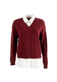 Maglione bordeaux a scollo a V indossato sopra una camicia bianca, con motivo a pois. Morbido misto lana con polsini e orlo a costine.