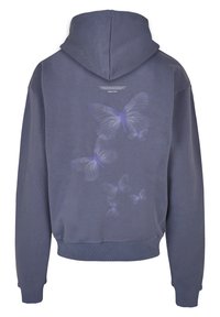 Mørkeblå hettegenser med snøring, med lilla sommerfugl-grafikk og ribbestrikkede mansjetter og hem. Tekstdetalj over sommerfuglene.
