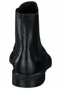 Stivali neri in pelle fino alla caviglia con una texture liscia, caratterizzati da un dettagli decorativo in brogue lungo la cucitura posteriore e un tacco basso impilato.