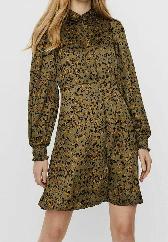 Olivgrön klänning med knäppning fram, långa puffärmar och elastiska manschetter. Har ett spritt mönster i mörk och senapsgul färg.