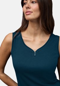 Top senza maniche blu navy con scollatura a V, caratterizzato da due bottoni decorativi sul collo e un tessuto liscio e testurizzato.