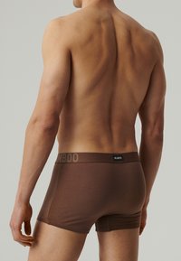 Brązowe bokserki wykonane z bambusa z kontrastującym pasem oznaczonym napisem "BAMBOO" oraz mniejszą metką "ATLANTIC" z tyłu. Gładka tekstura, dopasowany krój.