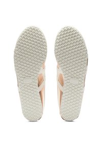 Tenisky s světle růžovým svrškem, bílými křížovými pásky a texturovanou gumovou podrážkou s diamantovým vzorem pro lepší grip.