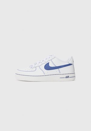 Witte lage sneaker met blauwe Nike-swoosh, blauwe stiksels en de tekst "AIR" op de zool, gezien vanaf de buitenkant tegen een effen achtergrond.