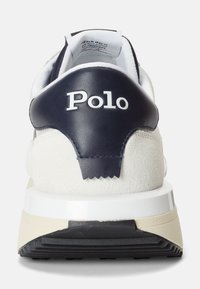 Biały trampki z granatowym skórzanym zapiętkiem, ozdobione teksturowanymi zamszowymi detalami i białym logo "Polo". Gumowa podeszwa z kontrastującymi beżowymi elementami.