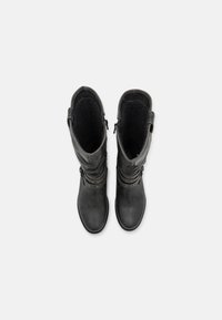 Bottes noires en cuir montantes avec une finition texturée, dotées de sangles décoratives et de matériel en métal, et d'un intérieur en doux gris.