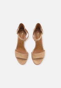 Paire de sandales beiges en daim à bouts ouverts avec brides à la cheville et petits talons blocs, taille 37, sur fond blanc.