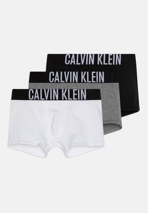 Tri parova muških bokserica u bijeloj, sivoj i crnoj boji. Svaka ima rastezljivu elastiku s printom "CALVIN KLEIN" u podebljanom slovu.