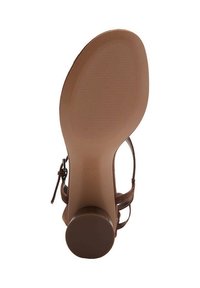 Brune hæl sandal med en glat sål. Har en rund hæl og tynde ankelstropper. Tekstureret fodseng med vandrette riller.