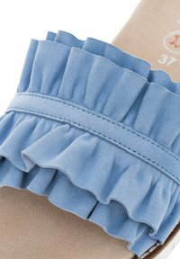 Blauwe suède slide-sandaal met een gerimpelde band, zachte textuur en een gladde beige binnenzool. Heeft een gestikte detaillering op de band.