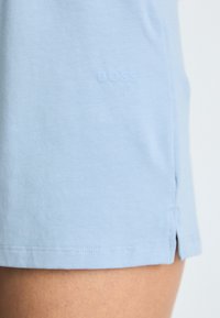 Lichtblauwe katoenen shorts met een lichte glans. Voorzien van een subtiele "BOSS" logo in bijpassende kleur nabij de zoom en zijsplitten voor extra comfort.