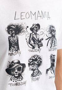 White t-shirt featuring six stylized leopard illustrations. Text includes days of the week. Black ink with varying hairstyles and accessories.