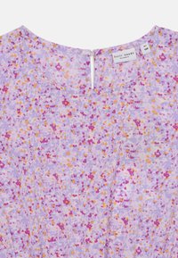 Robe florale en lavande avec des taches roses, jaunes et violettes. Elle présente un col rond et une fermeture éclair au dos. Tissu léger.