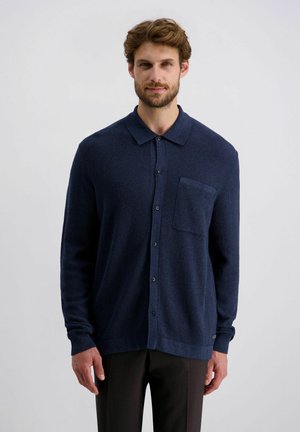 Marineblaue, strukturierte Hemdbluse mit Kragen, langen Ärmeln, einer Brusttasche und leichtem Stoff. Einfaches Design ohne Muster.