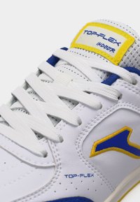 Λευκό αθλητικό παπούτσι με μπλε και κίτρινες λεπτομέρειες, λευκά κορδόνια, διάτρητη γλώσσα και ετικέτα "TOP-FLEX INDOOR" στη γλώσσα.