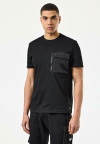 Sort T-shirt med rund hals, der har en tekstureret sort lynlåslomme på venstre bryst og korte ærmer.